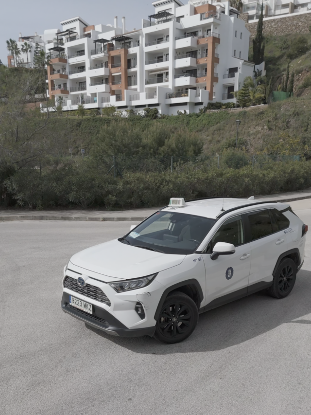 Professional Taxi service in Torrox with a white hybrid SUV parked in an urban area of ​​the Costa del Sol.